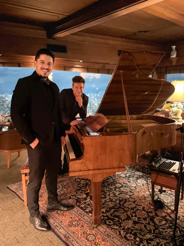 Pianista e cantor da Acustify em restaurante com vista para a cidade